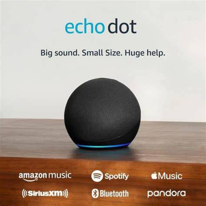 Echo Dotr Image 1 of Amazon Echo Dot image on white surface with Android figurine in background.