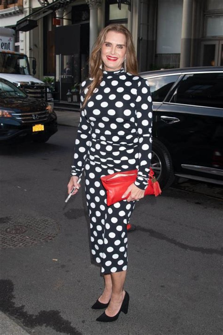 Brooke Shields wearing a polka dot top, and red lipstick.
