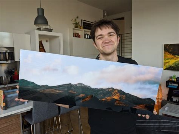David Imel holding a large print of his photography David Imel holding a large print of his photography