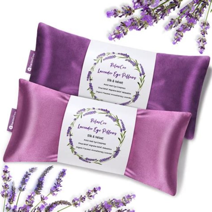 Five pastel satin eye pillows next to a bundle of sage