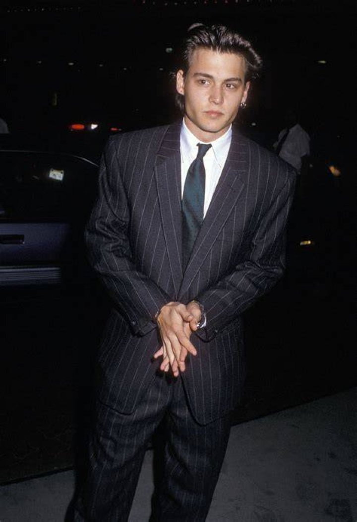 Johnny Depp in a suit and Amber Heard in a suit.