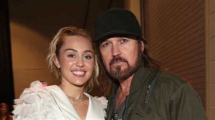 Miley Cyrus and her dad Billy Ray Cyrus attending a hannah montana movie premiere 
