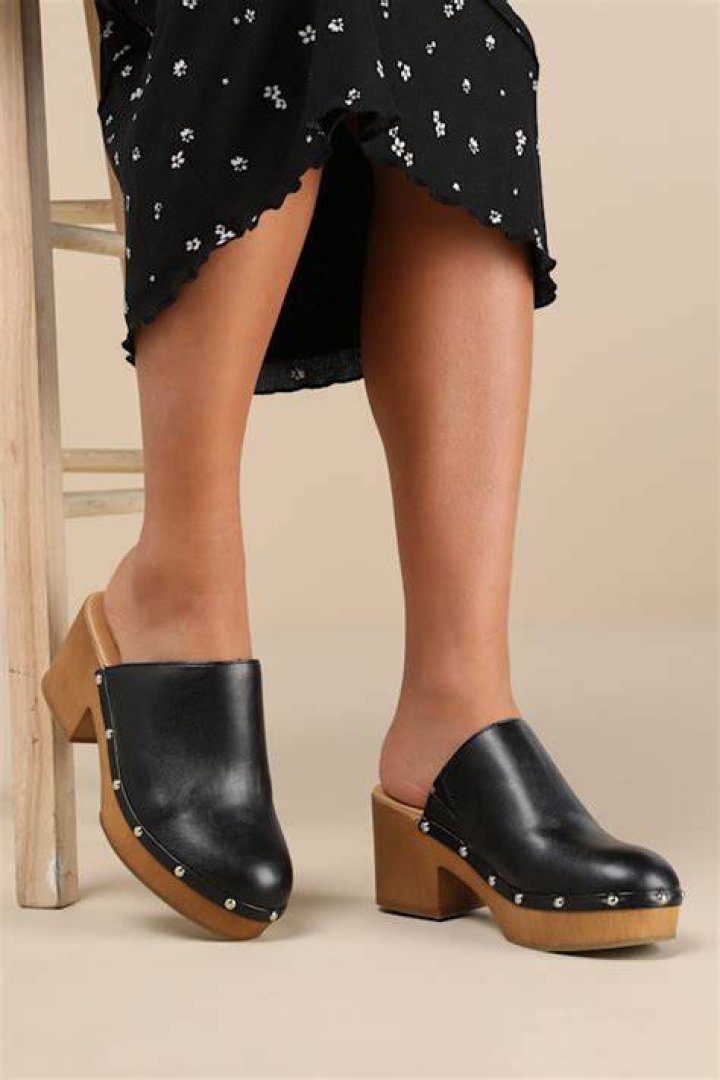 sleek black clogs with silver medallions